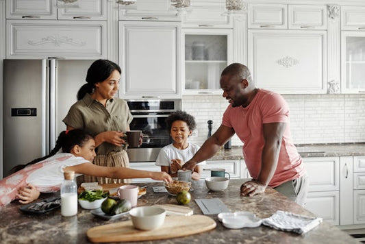 Family in kitchen, mum and dad with children busy at table, stock image from Pexels.